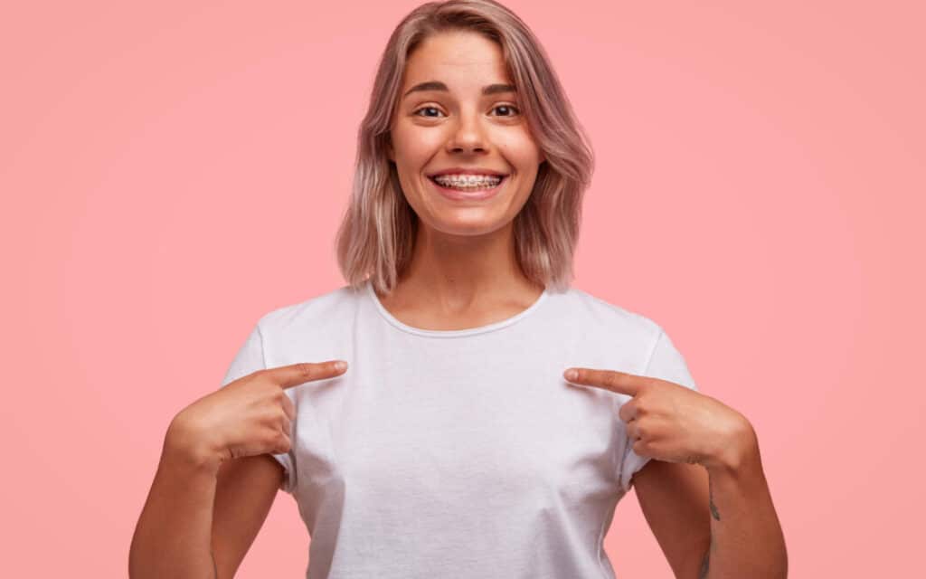 Young woman smiling with braces after orthodontic treatment showing straight teeth results