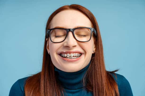 Teen girl smiling with braces during orthodontic treatment for teeth alignment